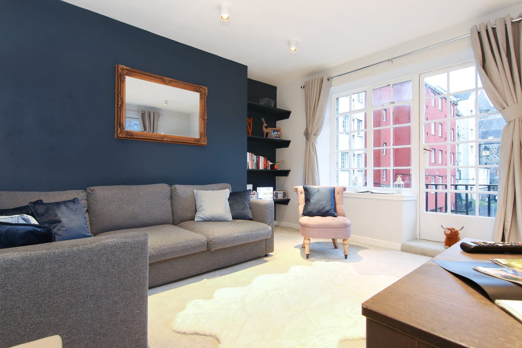 Living room with navy feature wall, mirror and sofa